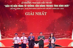 Đại tướng Phan Văn Giang, Ủy viên Bộ Chính trị, Bộ trưởng Bộ Quốc phòng và đồng chí Nguyễn Xuân Thắng, Ủy viên Bộ Chính trị, Chủ tịch Hội đồng Lý luận Trung ương, Giám đốc Học viện Chính trị Quốc gia Hồ Chí Minh trao giải cho các tác giả, nhóm tác giả đoạt giải Nhất. (Ảnh: Thanh Tùng/TTXVN)