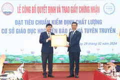 Tiến sỹ Nguyễn Đình Huy, Phó Giám đốc Trung tâm Kiểm định Chất lượng Giáo dục-Trường Đại học Vinh trao Giấy chứng nhận đạt tiêu chuẩn chất lượng cơ sở giáo dục cho Học viện Báo chí và Tuyên truyền. (Ảnh: Lê Hằng-Minh Trang/Vietnam+)
