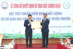 Tiến sỹ Nguyễn Đình Huy, Phó Giám đốc Trung tâm Kiểm định Chất lượng Giáo dục-Trường Đại học Vinh trao Giấy chứng nhận đạt tiêu chuẩn chất lượng cơ sở giáo dục cho Học viện Báo chí và Tuyên truyền. (Ảnh: Lê Hằng-Minh Trang/Vietnam+)