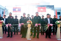 Đại diện Bộ Quốc phòng Việt Nam và Lào cắt băng khánh thành và bàn giao Công trình. (Ảnh: Phạm Kiên/TTXVN)