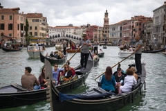 Khách du lịch đi thuyền gondola tại Venice, Italy. (Ảnh: AFP/TTXVN)