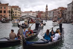 Khách du lịch đi thuyền gondola tại Venice, Italy. (Ảnh: AFP/TTXVN)