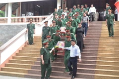 Các đại biểu đưa các liệt sỹ về an táng tại nghĩa trang. (Ảnh: Nguyên Dung/TTXVN)