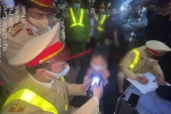 Lực lượng Cảnh sát Giao thông kiểm tra nồng độ cồn đối với người điều khiển xe ôtô va chạm trên phố Trần Cung, Hà Nội. (Ảnh: TTXVN phát)