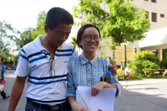 Thí sinh vui vẻ trao đổi thông tin với người thân sau giờ thi. (Ảnh: Lê Minh Sơn/Vietnam+)