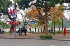 Cờ Mỹ, cờ Triều Tiên và cờ Việt Nam, bên dưới là biểu tượng hai bàn tay bắt chặt vào nhau thể hiện tinh thần của cuộc gặp lớn, được treo trên phố Đinh Tiên Hoàng, quang hồ Hoàn Kiếm. (Ảnh: Ngọc Hà/TTXVN) 
