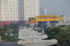 Lao lắp các đốt dầm đoạn trên cao tuyến metro số 1. (Ảnh: Trần Xuân Tình/TTXVN)