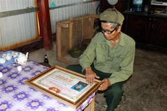 Binh nhất Tao Văn Nó với Bằng khen của Hội Cựu chiến binh tỉnh Lai Châu trao tặng. (Ảnh: Công Tuyên/TTXVN)