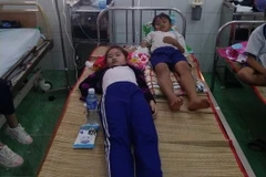 Các em học sinh đang điều trị tại Bệnh viện đa khoa huyện Trần Văn Thời. (Ảnh: Huỳnh Thế Anh/TTXVN)