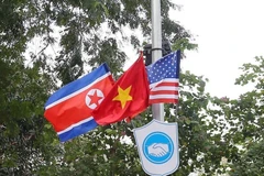 Cờ Mỹ, cờ Triều Tiên và cờ Việt Nam, bên dưới là biểu tượng hai bàn tay bắt chặt vào nhau thể hiện tinh thần của cuộc gặp lớn được treo trên các tuyến phố xung quanh hồ Hoàn Kiếm. (Ảnh: Danh Lam/TTXVN)