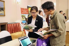 Doanh nghiệp Hội An giới thiệu với khách hàng các gói sản phẩm, dịch vụ tour. (Ảnh: Mỹ Phương/TTXVN)