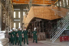 Trung tướng Ngô Minh Tiến cùng đoàn công tác kiểm tra xưởng đóng tàu gỗ tại Nhà máy X51. (Ảnh: Hồng Pha/TTXVN phát)