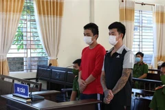 Hai bị cáo Nguyễn Hữu Tài và Phạm Nhật Quang tại tòa. (Ảnh: TTXVN phát)