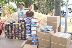 Hai đối tượng cùng tang vật bị lực lượng chức năng bắt giữ. (Ảnh: Đậu Tất Thành/TTXVN)