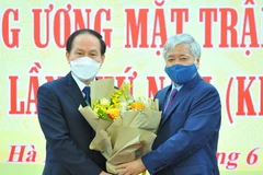 Chủ tịch Ủy ban Trung ương Mặt trận Tổ quốc Việt Nam Đỗ Văn Chiến tặng hoa chúc mừng Phó Chủ tịch, Tổng Thư ký Ủy ban Trung ương Mặt trận Tổ quốc Việt Nam Lê Tiến Châu. (Ảnh: Minh Đức/TTXVN)