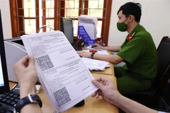 Giấy đi đường có mã nhận diện được lực lượng công an phường Văn Quán, quận Hà Đông đối chiếu và xét duyệt để cấp cho các cá nhân và doanh nghiệp thực hiện dịch vụ công ích thiết yếu trên địa bàn. (Ảnh: Phạm Kiên/TTXVN)