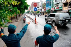 Các lực lượng chức năng hướng dẫn người dân quay đầu xe khi đi vào quận Gò Vấp. (Ảnh: An Hiếu/TTXVN)