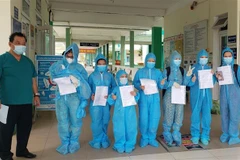 Giám đốc Bệnh viện Phổi Đà Nẵng trao giấy chứng nhận khỏi bệnh và xuất viện cho các bệnh nhân mắc COVID-19. (Ảnh: Văn Dũng/TTXVN)
