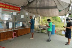 Người dân khai báo y tế tại Chốt kiểm dịch nút giao IC 12, cao tốc Nội Bài-Lào Cai. (Ảnh: Tuấn Anh/TTXVN)