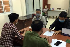 Em N.H.L (áo đen) khai nhận sự việc tại cơ quan công an. (Ảnh TTXVN phát)