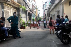 Lực lượng chức năng lập rào chắn khu vực cách ly tạm thời là một phần hẻm 359. (Ảnh: Thanh Vũ/TTXVN)