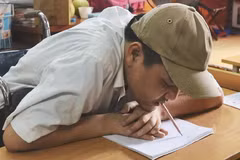 Anh Phùng Văn Trường viết chữ bằng miệng. (Ảnh: PV/Vietnam+)