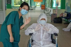 Bệnh nhân 3221 mắc COVID-19 nặng, lớn tuổi (áo trắng) được điều trị khỏi và xuất viện. (Ảnh: TTXVN phát)