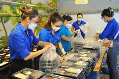 Các đoàn viên thanh niên chuẩn bị các suất cơm để chuyển tới tay những công nhân lao động, sinh viên nghèo, hộ khó khăn và người khuyết tật bị ảnh hưởng bởi dịch bệnh COVID-19. (Ảnh: Minh Đức/TTXVN)