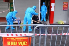 Người dân liên quan đến ca F0 ở số 21 Trần Nhân Tông được lấy mẫu xét nghiệm. (Ảnh: Hoàng Hiếu/TTXVN)