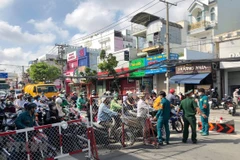 Lực lượng chức năng tại chốt kiểm soát cầu Chợ Cầu hướng dẫn người dân khai báo y tế, cũng như hướng dẫn lưu thông theo quy định. (Ảnh: TTXVN phát)