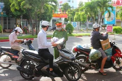 Lực lượng chức năng trên địa bàn thành phố Bạc Liêu (tỉnh Bạc Liêu) kiểm tra giấy đi đường của người tham gia giao thông. (Ảnh: Chanh Đa/TTXVN)
