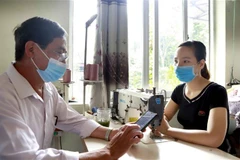 Điều tra viên thu thập thông tin, phỏng vấn một số chủ cơ sở sản xuất kinh doanh. (Ảnh: Hoàng Hùng/TTXVN)