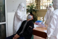 Nhân viên y tế lấy mẫu xét nghiệm SARS-CoV-2 cho các lái xe. (Ảnh: Mạnh Tú/TTXVN)