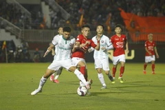 Pha tranh bóng giữa các cầu thủ giữa đội chủ nhà Thành phố Hồ Chí Minh (áo đỏ) và đội Bình Định (áo trắng). (Ảnh: Thanh Vũ/TTXVN)