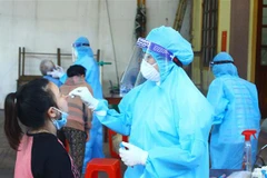 Cán bộ y tế lấy mẫu xét nghiệm cho người dân phường Hà Huy Tập, thành phố Vinh, tỉnh Nghệ An. (Ảnh: Tá Chuyên/TTXVN)
