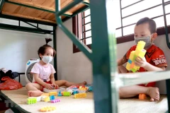 Hai em nhỏ cùng phòng tại một khu cách ly. (Ảnh: Hoàng Hùng/TTXVN)