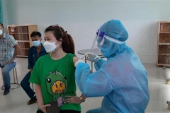 Người dân phường 'vùng xanh' Tương Bình Hiệp, thành phố Thủ Dầu Một, tỉnh Bình Dương tiêm vaccine phòng COVID-19. (Ảnh: Chí Tưởng/TTXVN)