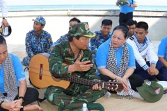 Thiếu tướng Nguyễn Hồng Sơn (ôm đàn) đang giới thiệu cho chiến sỹ, cán bộ trên đảo Đá Thị về bài hát 'Phút lặng im trên biển' do ông sáng tác. (Ảnh: Sỹ Tuyên/TTXVN)