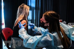 Tiêm vaccine ngừa COVID-19 tại Miami, Mỹ. (Ảnh: AFP/TTXVN)