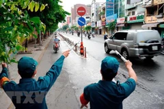 Các lực lượng chức năng hướng dẫn người dân quay đầu xe khi đi vào quận Gò Vấp. (Ảnh: An Hiếu/TTXVN)