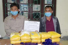 Hai đối tượng Giàng Seo Pà và Vừ A Sinh cùng tang vật 60.000 viên ma túy tổng hợp. (Ảnh: TTXVN phát)