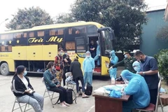 Kiểm tra y tế đối với hành khách trên xe giường nằm chở người nhập cảnh trái phép. (Nguồn: Cand.com.vn)