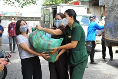 Lực lượng tình nguyện vận chuyển nhu yếu phẩm cho nhân dân phường Chương Dương và Phúc Tân. (Ảnh: Minh Đức/TTXVN)