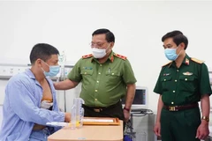 Trung tướng Nguyễn Hải Trung mong anh Nguyễn Trần Minh tiếp tục phát huy tinh thần dũng cảm, làm nhiều việc tốt hơn nữa, góp phần giữ gìn an ninh, trật tự. (Ảnh: TTXVN phát)