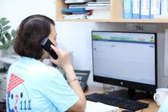 Chị Hoàng Lê Thủy, nhân viên tư vấn của Tổng đài điện thoại quốc gia bảo vệ trẻ em 111 đặt tại Hà Nội, trả lời các cuộc gọi. (Ảnh: Anh Tuấn/TTXVN)