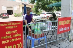 Người dân nhận đồ chuyển từ bên ngoài vào. (Ảnh: Thanh Tùng/TTXVN)