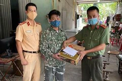 Cán bộ chiến sỹ chốt kiểm dịch Sơn Nam tặng anh Minh mỳ tôm và 500.000 đồng. (Ảnh: TTXVN phát)