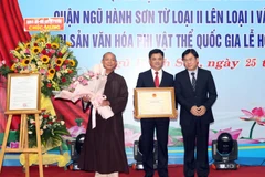 Ông Nông Quốc Thành, Phó Cục Trưởng Cục Di sản văn hóa (Bộ Văn hóa, Thể thao và Du lịch) trao Bằng chứng nhận Lễ hội Quán Thế Âm-Ngũ Hành Sơn là Di sản văn hóa phi vật thể quốc gia cho đại diện chính quyền và nhân dân quận Ngũ Hành Sơn. (Ảnh: Trần Lê Lâm/