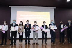 Phó Chủ tịch Thường trực Ủy ban Nhân dân thành phố Đà Nẵng Hồ Kỳ Minh (thứ 4 từ trái sang) trao 6 giấy chứng nhận đăng ký đầu tư và 1 chủ trương nghiên cứu đầu tư cho các doanh nghiệp. (Ảnh: Quốc Dũng/TTXVN)