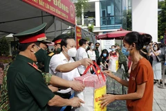 Trao quà cho các hộ nghèo, gia đình chính sách, người lao động mất việc làm... (Ảnh: Trần Việt/TTXVN)